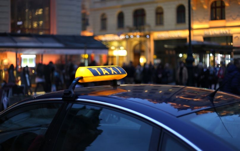 Schwarzes Taxi mit leuchtenden Taxischild